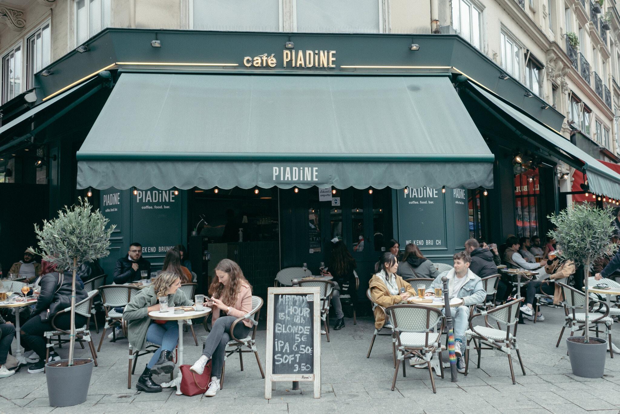 Người dân ngồi trong quán cà phê ở Paris hồi tháng 5 mà không cần đeo khẩu trang. Ảnh: New York Times.