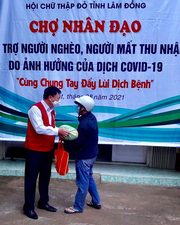 Ông Đỗ Hoàng Tuấn - Chủ tịch Hội Chữ thập đỏ trao quà cho người khó khăn đến Chợ Nhân đạo mua hàng thiết yếu