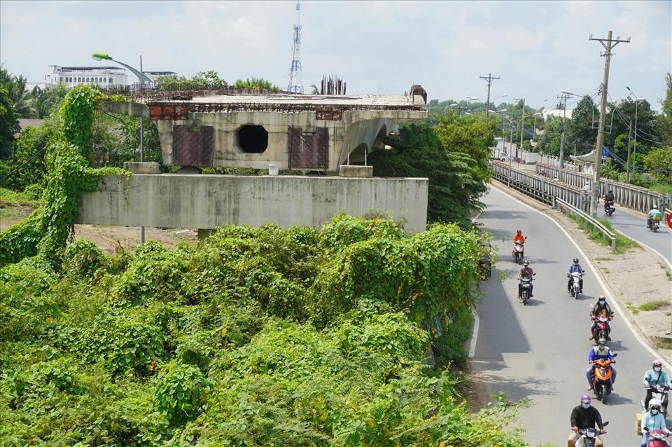 Do công trường dự án cầu Tăng Long bỏ hoang nhiều năm, cây dại mọc um tùm lên trụ và dầm cầu. Ảnh: Minh Quân.