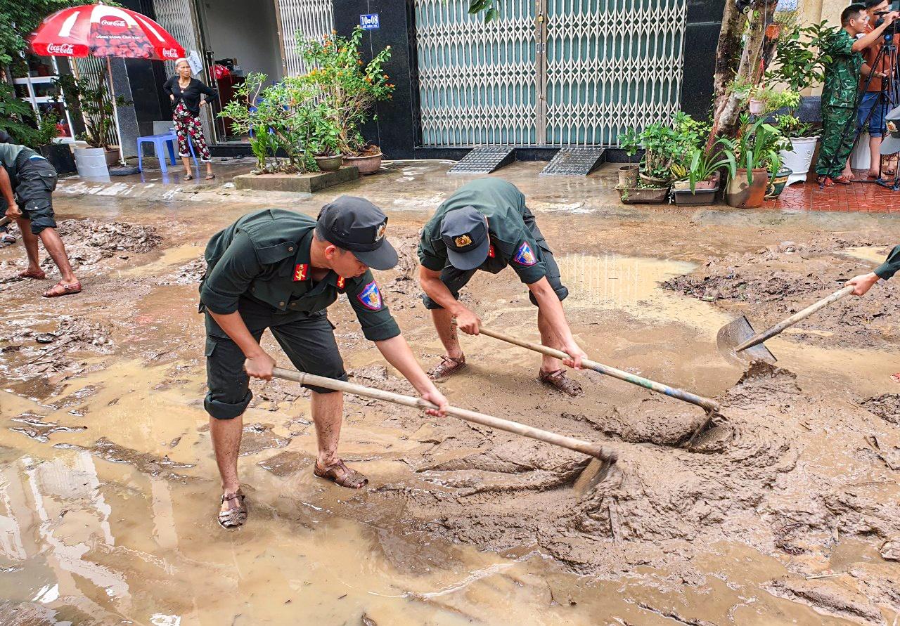 Dọn dẹp bùn đất trên các tuyến đường ở phường Ghềnh Ráng, TP Quy Nhơn. Ảnh: T. Thắng.