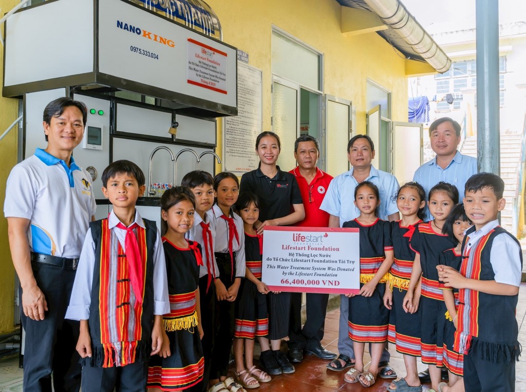 Các em học sinh Trường phổ thông dân tộc bán trú tiểu học và THCS Phước Lộc tiếp nhận hệ thống lọc nước do Tổ chức Lifestart Foundation tài trợ