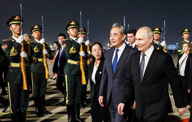 Bộ trưởng Ngoại giao Trung Quốc Vương Nghị đón Tổng thống Nga Vladimir Putin tại Sân bay quốc tế Thủ đô Bắc Kinh tối 19/5. Ảnh: TASS.