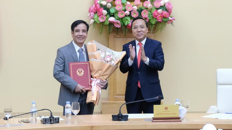 Thứ trưởng Nguyễn Hoàng Long trao Quyết định và tặng hoa ông Trần Anh Tấn.