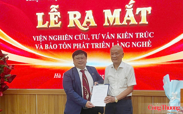 Ông Trịnh Quốc Đạt, Chủ tịch Hiệp hội Làng nghề Việt Nam (bên trái), trao quyết định thành lập Viện Nghiên cứu, Tư vấn Kiến trúc và Bảo tồn phát triển Làng nghề cho ThS.KTS Nguyễn Khánh Hiệp, Viện trưởng.